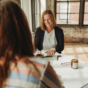 Two women at a table, having a conversation.
